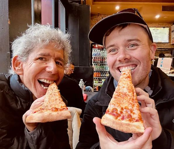 Tasty Tours NYCのツアーに参加している、二人がピザーを食べているシーン